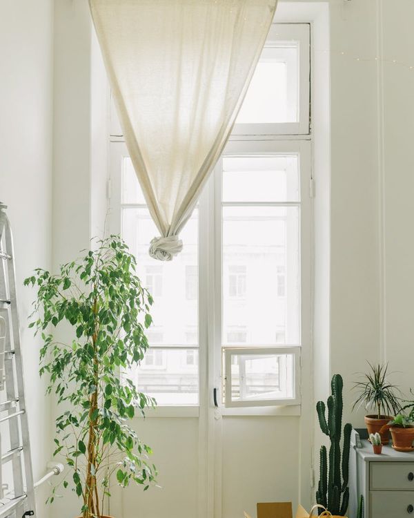 Person stretching peacefully in a bright, airy room with natural light.